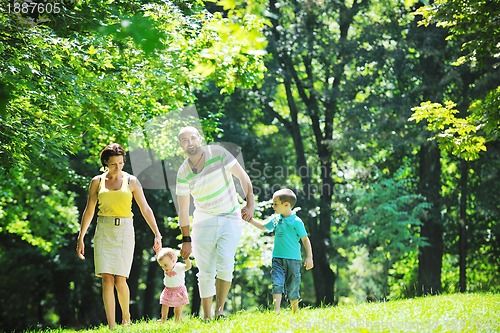 Image of happy young couple with their children have fun at park
