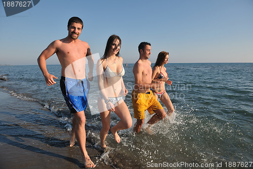 Image of happy people group have fun and running on beach