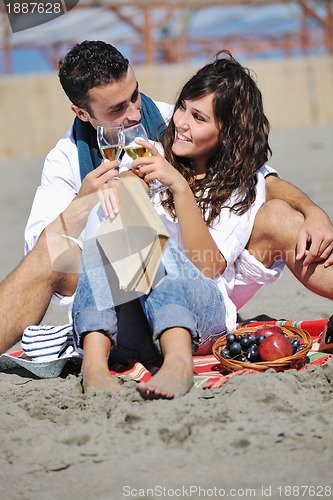 Image of young couple enjoying  picnic on the beach