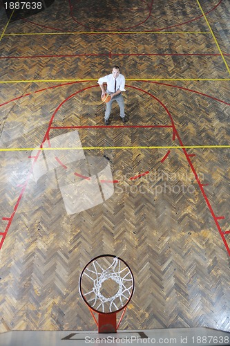 Image of businessman holding basketball ball