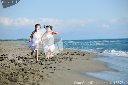 Image of cute little girls running on beach