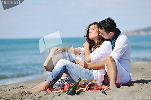 Image of young couple enjoying  picnic on the beach