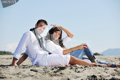 Image of young couple enjoying  picnic on the beach