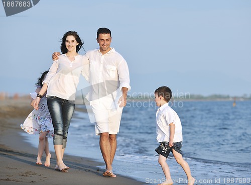 Image of happy young family have fun on beach at sunset