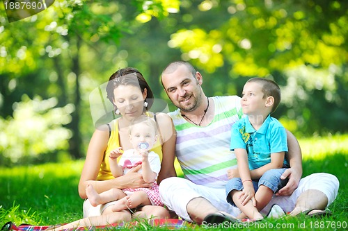 Image of happy young couple with their children have fun at park