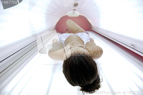 Image of Beautiful young woman tanning in solarium