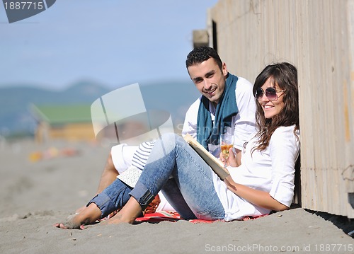 Image of young couple enjoying  picnic on the beach