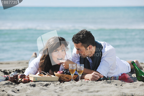 Image of young couple enjoying  picnic on the beach