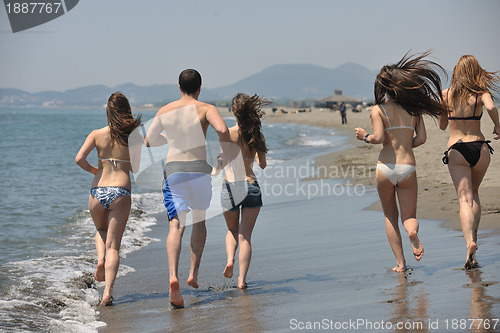 Image of happy people group have fun and running on beach