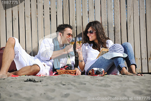 Image of young couple enjoying  picnic on the beach