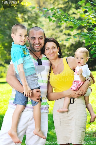 Image of happy young couple with their children have fun at park