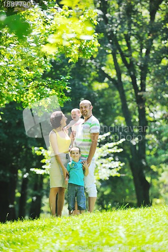 Image of happy young couple with their children have fun at park