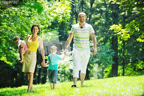 Image of happy young couple with their children have fun at park