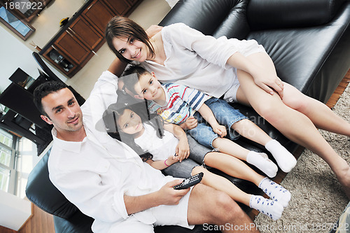 Image of family wathching flat tv at modern home indoor