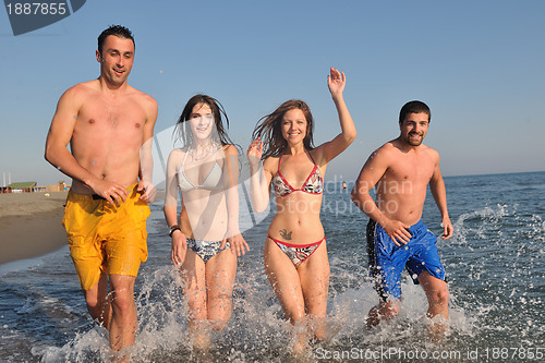 Image of happy people group have fun and running on beach