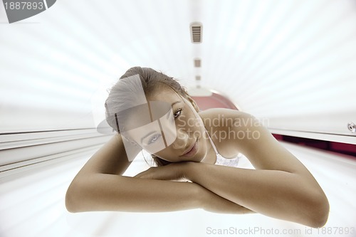 Image of Beautiful young woman tanning in solarium