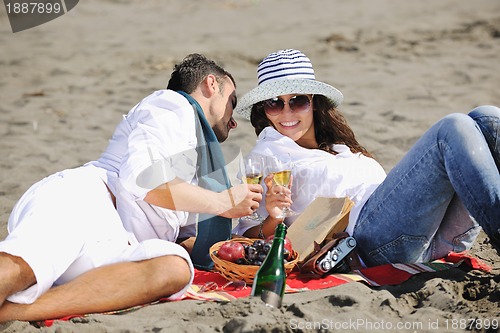 Image of young couple enjoying  picnic on the beach
