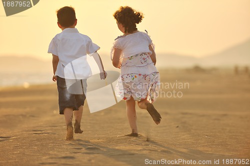 Image of happy young family have fun on beach at sunset