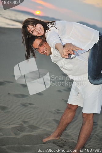 Image of happy young couple have fun on beach