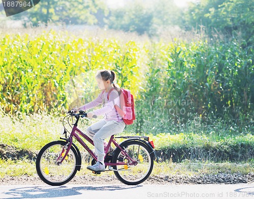 Image of schoolgirl traveling to school on bicycle