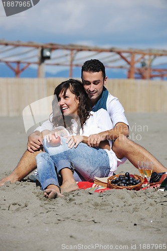 Image of young couple enjoying  picnic on the beach