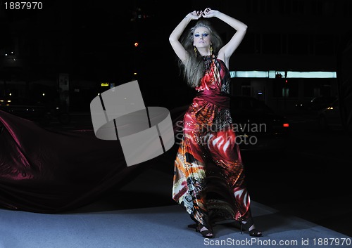 Image of elegant woman on city street at night