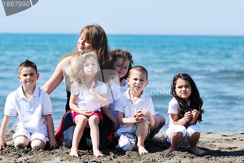 Image of group portrait of childrens with teacher on beach