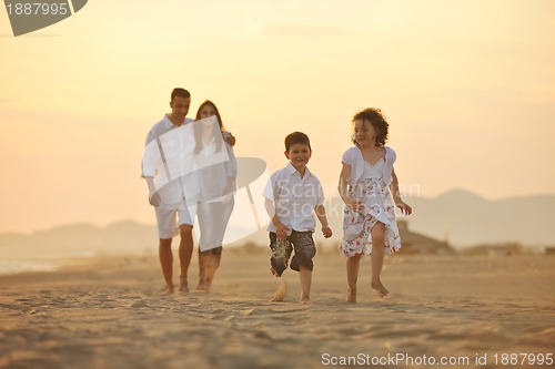 Image of happy young family have fun on beach at sunset