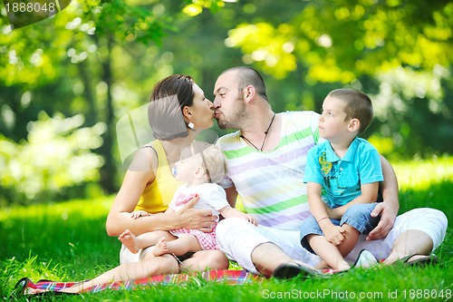 Image of happy young couple with their children have fun at park
