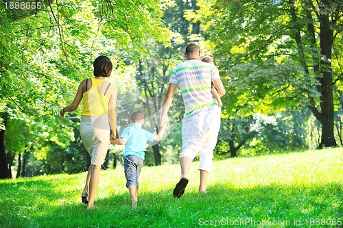 Image of happy young couple with their children have fun at park