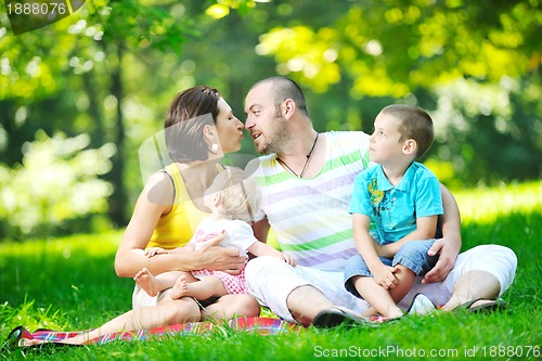 Image of happy young couple with their children have fun at park