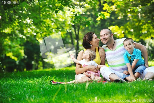 Image of happy young couple with their children have fun at park