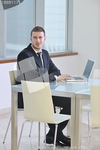 Image of young business man alone in conference room