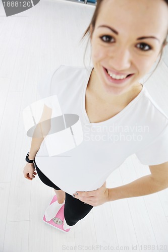 Image of happy diet concept with young woman on pink scale