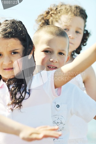 Image of happy child group playing  on beach
