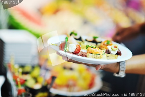 Image of womanl chooses tasty meal in buffet at hotel