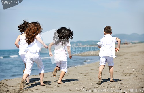 Image of happy child group playing  on beach