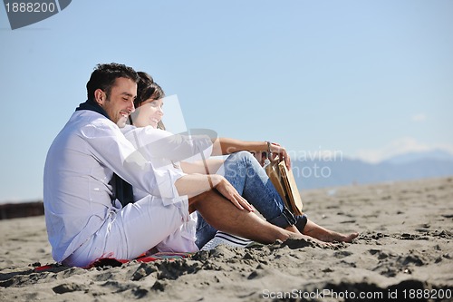 Image of young couple enjoying  picnic on the beach