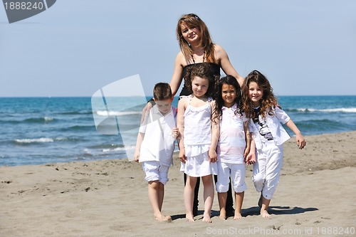 Image of group portrait of childrens with teacher on beach