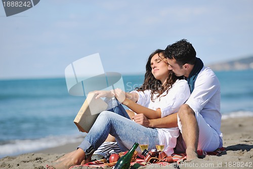 Image of young couple enjoying  picnic on the beach