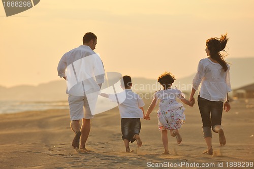 Image of happy young family have fun on beach at sunset
