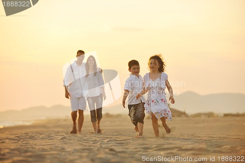 Image of happy young family have fun on beach at sunset