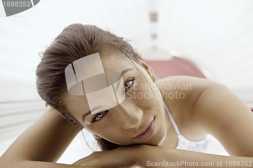 Image of Beautiful young woman tanning in solarium