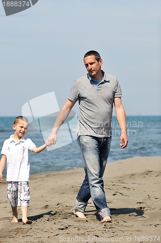 Image of happy father and son have fun and enjoy time on beach