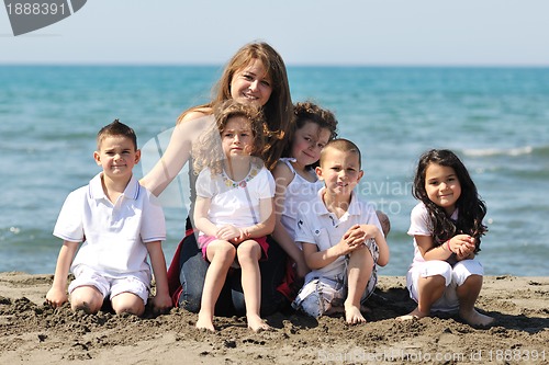 Image of group portrait of childrens with teacher on beach