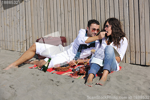 Image of young couple enjoying  picnic on the beach