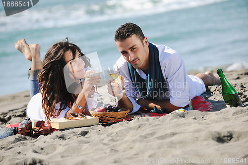 Image of young couple enjoying  picnic on the beach