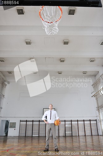 Image of businessman holding basketball ball