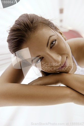 Image of Beautiful young woman tanning in solarium