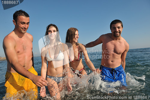 Image of happy people group have fun and running on beach